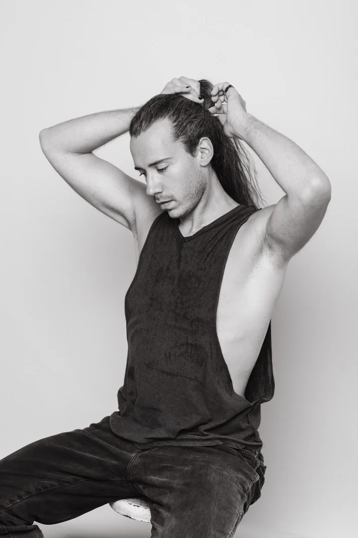 Zeyan Castracane. Gathering long hair with both hands. Black-and-white portrait.