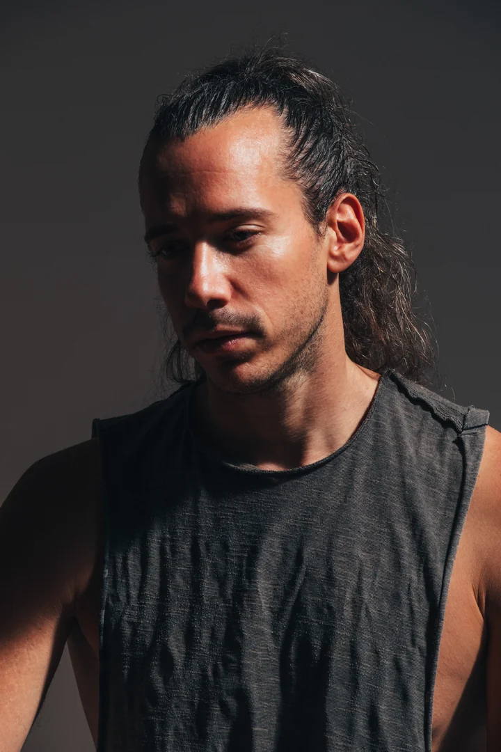 Zeyan Castracane. Close-up with hair tied back and a dark sleeveless top. Colour portrait.
