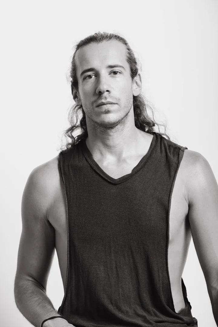 Zeyan Castracane. Facing the camera in a sleeveless top, long hair behind the shoulders. Black-and-white portrait.