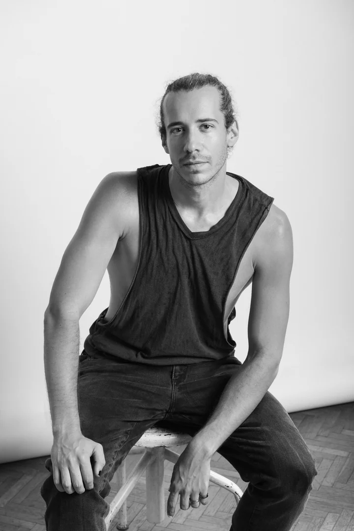 Zeyan Castracane. Seated on a stool, facing the camera. Black-and-white portrait.